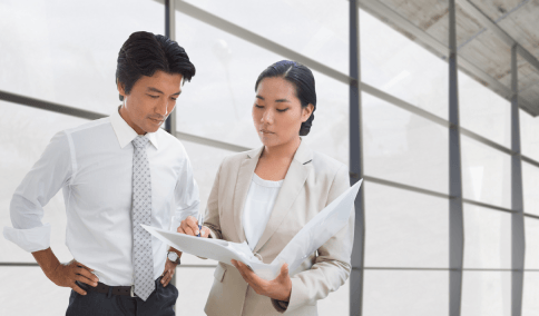 A translator signs certified board documents translated by Korean Translation Services in New York City for compliance.