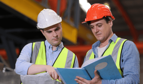 An engineer reviews a CAD manual with Translation Services in Williamsburg for technical terms and measurement accuracy.
