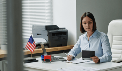 A translator formats bilingual immigration forms on screen, as Translation Services in Harlem checks USCIS requirements.